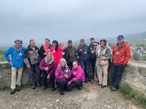 Gruppe stößt mit Weingläsern über den Weinbergen an